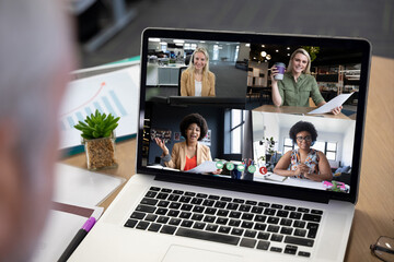 Diverse businesswomen displayed on laptop screen during office video call