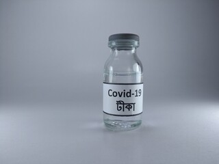 The word Covid 19 vaccine written in Bengali language on a bottle of vaccine 