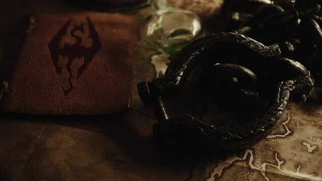 Tilt-up shot of a leather Viking book with a rune over a table and other Viking stuff.