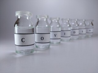 Close up shot of vaccine bottles and covid 19 written on them