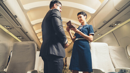 Cabin crew greeting passenger in airplane . Airline transportation and tourism concept.