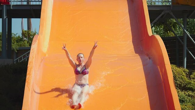 Young woman having fun on water slides
