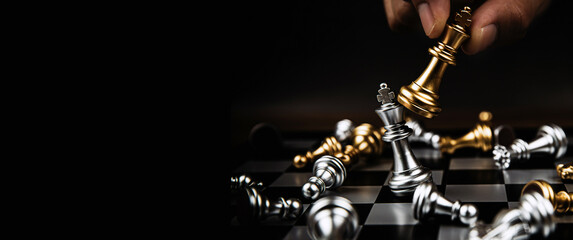 Close up hand choose the king gold chess to fight with silver team on chess board. Concept of business team and leadership and strategic plan challenge management.