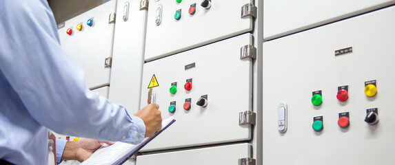 Electrical engineer checking electrical voltage at circuit breaker air handling unit (AHU) starter...