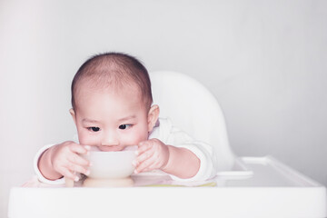 Asian babies are eating deliciously in the cup,