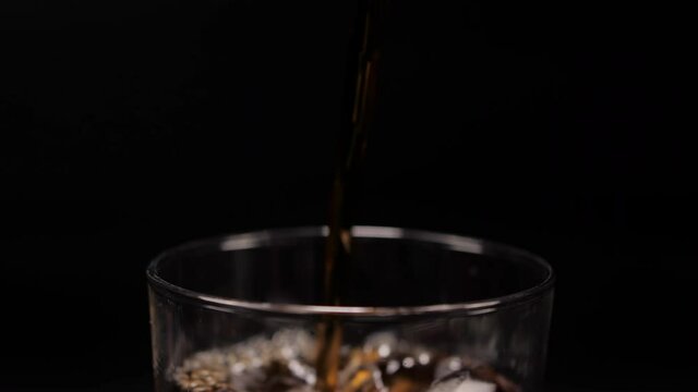 pouring ice cubes and cola coke in cold glass 4k