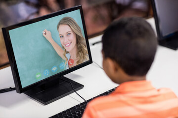 Mixed race schoolboy using computer on video call with female teacher