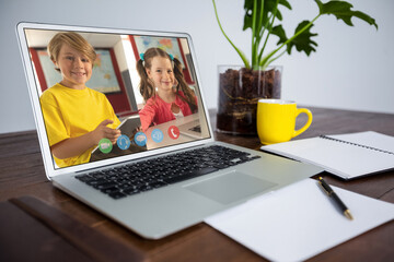 Caucasian schoolboy and schoolgirl learning displayed on laptop screen during video call