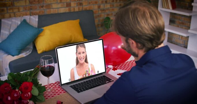 Caucasian couple on a valentines date video call man waving to smiling woman holding bouquet on lapt