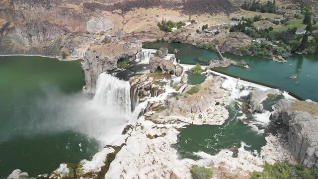 Slow motion aerial view high above Shoshone Falls pouring into the Snake River in Twin Falls, Idaho during the summer.