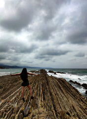 Girl in the strata rocks of zumaia