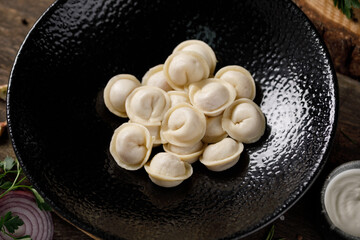 Appetizing traditional Russian dumplings, handmade. Still life on a wooden board. Close-up.