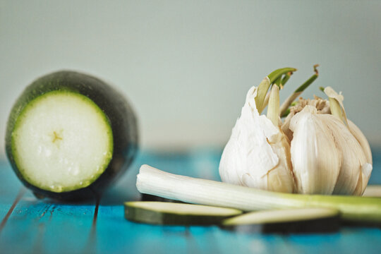 Close-up of garlic by eggplant and scallion on table
