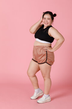A charming active big body sporty-looking girl in shorts and sport wear standing and smiling with self-confidence and positive face and emotion. Happy and self-esteem concept