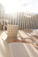 Cup of coffee, book and glasses outdoor sunset moment