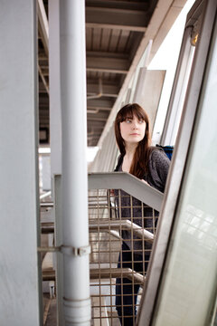 Woman looking away while climbing on stairs at railroad station