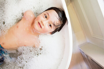 Overhead view of boy bathing at home