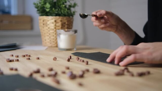 Pour hot wax on the envelope. Print paraffin. Blur. Selective focus. Black envelope and wood. Bronze Spoon.