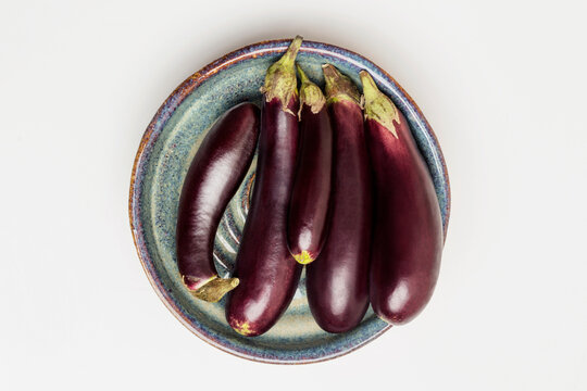 Overhead view of eggplants in bowl on white background