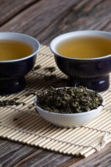 Leafy green tea next to two containers
