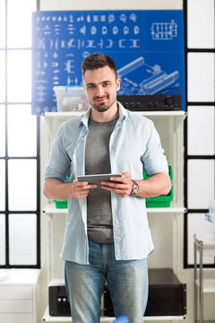 Portrait of confident engineer holding digital tablet in electronic laboratory