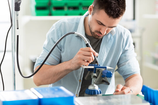 Concentrated engineer working on circuit board in electronic laboratory