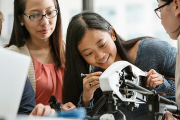 Teacher and students examining drone in classroom