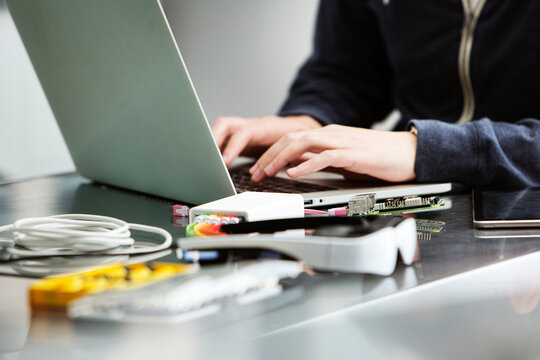 Midsection of male student using laptop at table