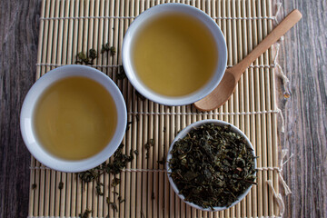 Leafy green tea next to two containers