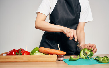 Cooking food healthy food kitchen black apron cutting vegetables