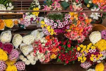 Indian flower vendors selling their garlands and assortment of flowers to locals in a local markets setup in India, Goa