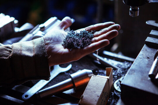 Cropped image of worker holding swarf in workshop