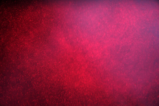 Abstract festive background with selective focus. Bright particles on dark red background. Splashes, space, energy flow