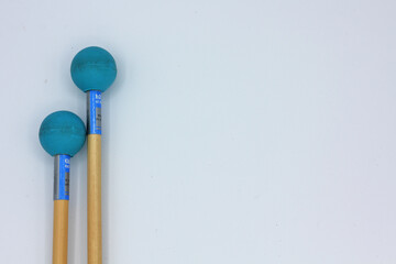 Detail of xylophone mallets in the left side on a white background.