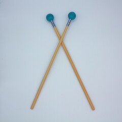 Crossed xylophone
mallets on a white background.