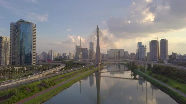 move in over Pinheiro river with a gorgeous view of estaiada bridge on a busy day with traffic and beautiful sunset