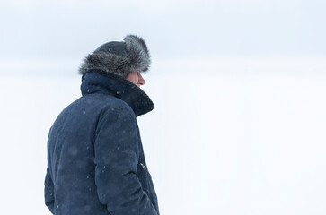 Fototapeta na wymiar A man in a flight jacket in a snowfall