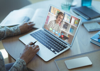 Mid section of female teacher having a video call with male student on laptop at school