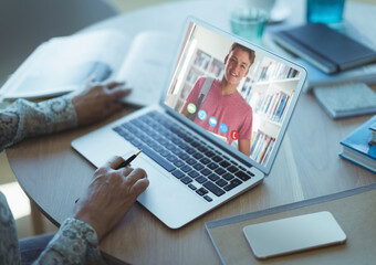 Female teacher having a videocall with male student on laptop at home