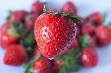 Red ripe strawberry against background of blurred fruits