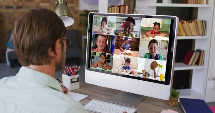 Caucasian male teacher using computer on video call with school children