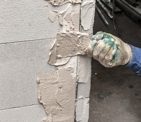 A worker plasters the walls in the room.