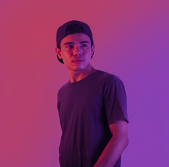 Obraz premium Young Man Portrait On Purple Studio Background In Neon Light