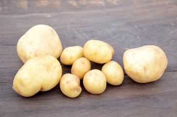 bunch the fresh ripe potato on the wooden background.