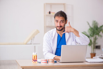 Naklejka premium Young male odontologist in telemedicine concept