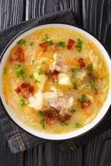 Polish Sauerkraut Soup Recipe Kapusniak closeup in the plate on the table. Vertical top view from above