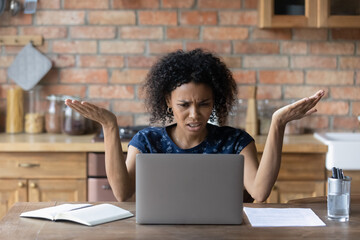 Close up unhappy irritated African American woman using laptop, looking at screen, having problem...