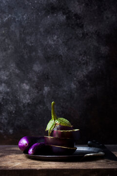 Close-up of eggplant in plate with knife on wooden table