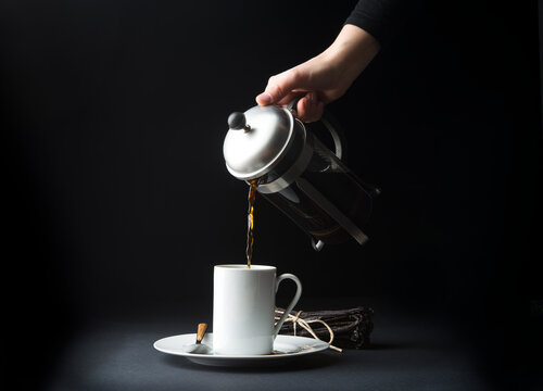 Cropped image of woman making coffee against black background