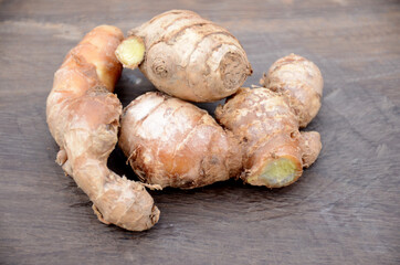 the brown ripe ginger on wooden background.